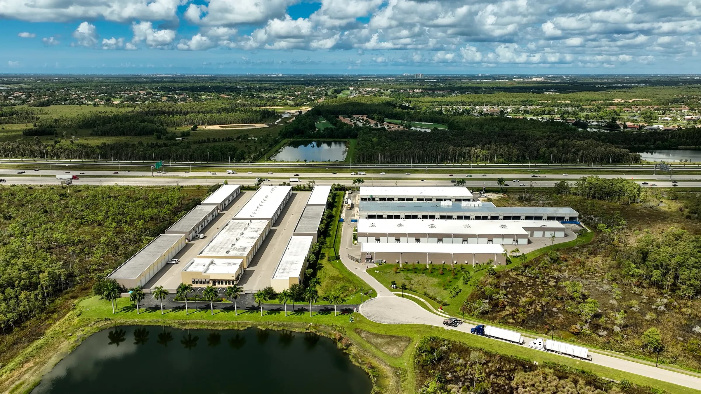 Aerial from the lake side showing the curving entrance drive, the building rows and I-75 beyond